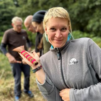 Eine lächelnde Teilnehmerin präsentiert stolz einen japanischen Pinsel. Die Freude am Erlernen neuer Techniken ist sichtbar.