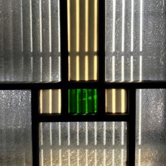 Ein Kunstwerk, das an Kirchenfenster erinnert, eingebettet in ein traditionelles japanisches Fenster