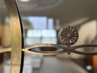 Eine dekorative Metalleinfassung mit einem Sonnenmotiv – ein stilisiertes Designelement, das auf die Bedeutung von Licht und Symbolik in der japanischen Gestaltung hinweist.